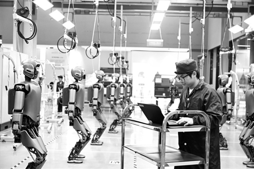 2025年6月18日,在广西柳州市北部生态新区机器人产业园,工人检查工业版人形机器人。新华社发